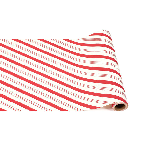 A roll of white table runner featuring diagonal red candy stripes and thin accent lines.