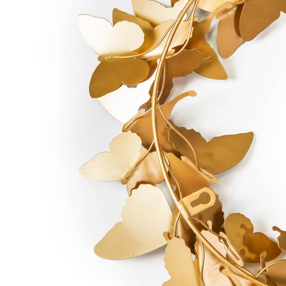 Close-up of a gold metal butterfly wreath showing detailed butterfly shapes and hanging hardware.