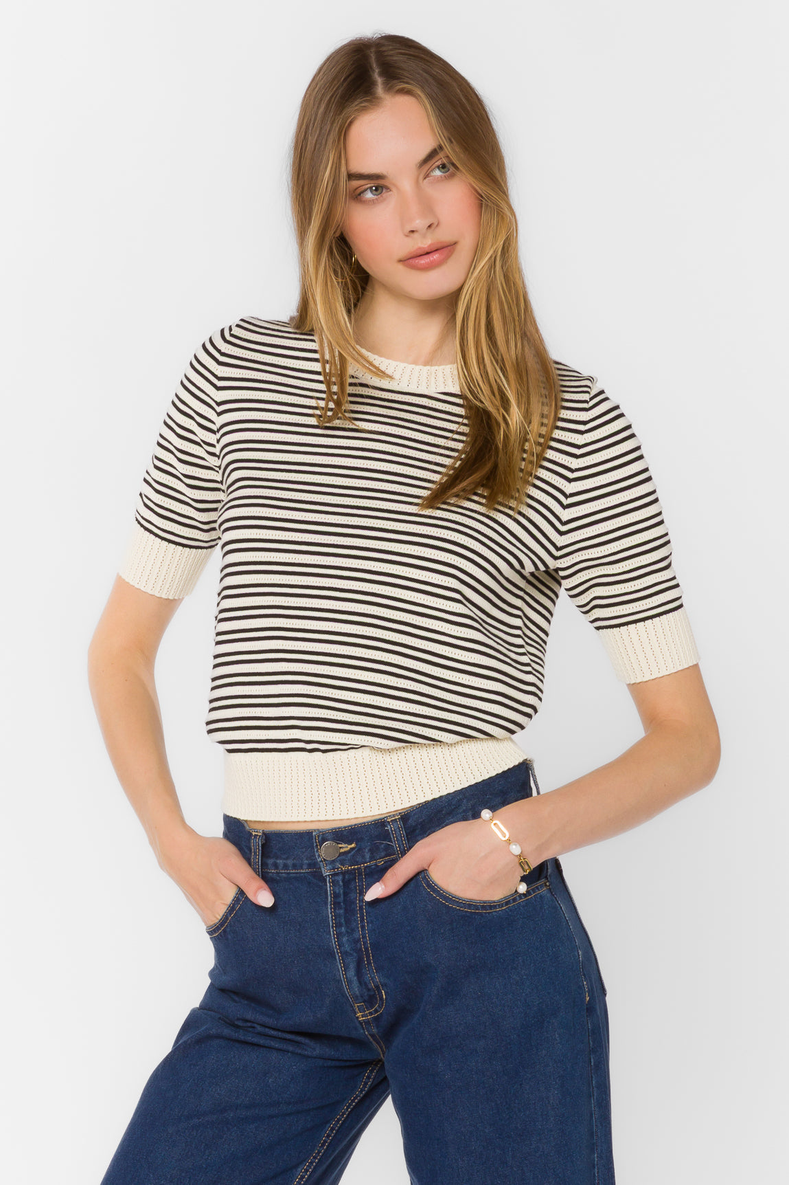 Woman wearing the Norine Stripe Sweater, a short sleeve cotton knit with black and white stripes.