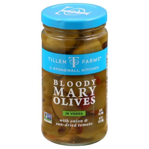 A jar of green olives with sun-dried tomatoes and onions in a Bloody Mary brine.