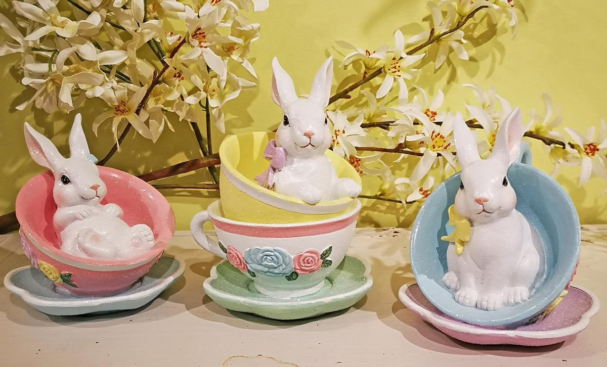 White bunny figurine sitting in a pastel teacup with saucer. Sold individually.