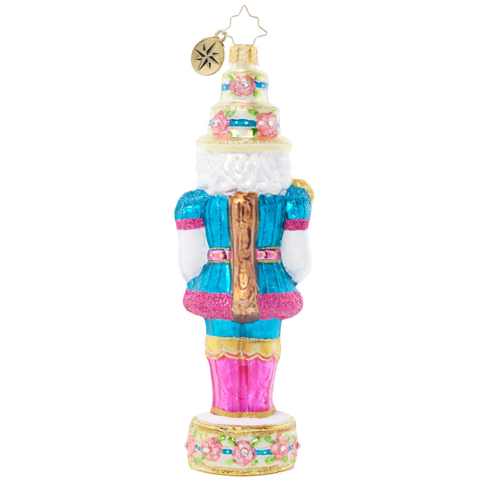 Back view of a Garden Party Guard nutcracker ornament with floral hat and blue glittered uniform.