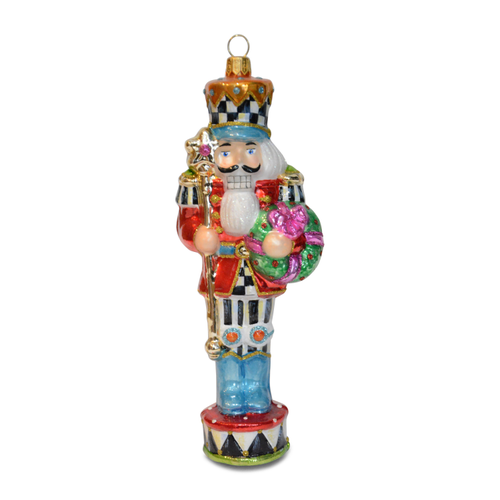 Confetti Christmas Nutcracker glass ornament with a glittery red coat, green wreath, and gold staff.