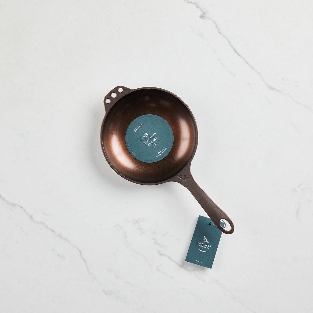 Top-down view of a No. 8 Chef Skillet with a polished finish and long handle on a marble surface.