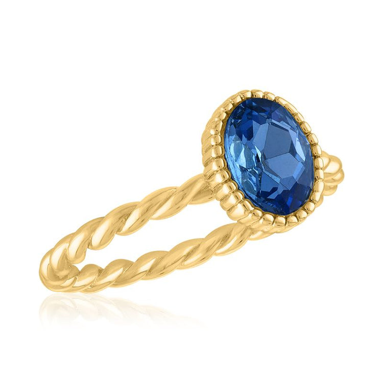 Light sapphire oval gemstone set in a gold-layered twisted rope band ring.