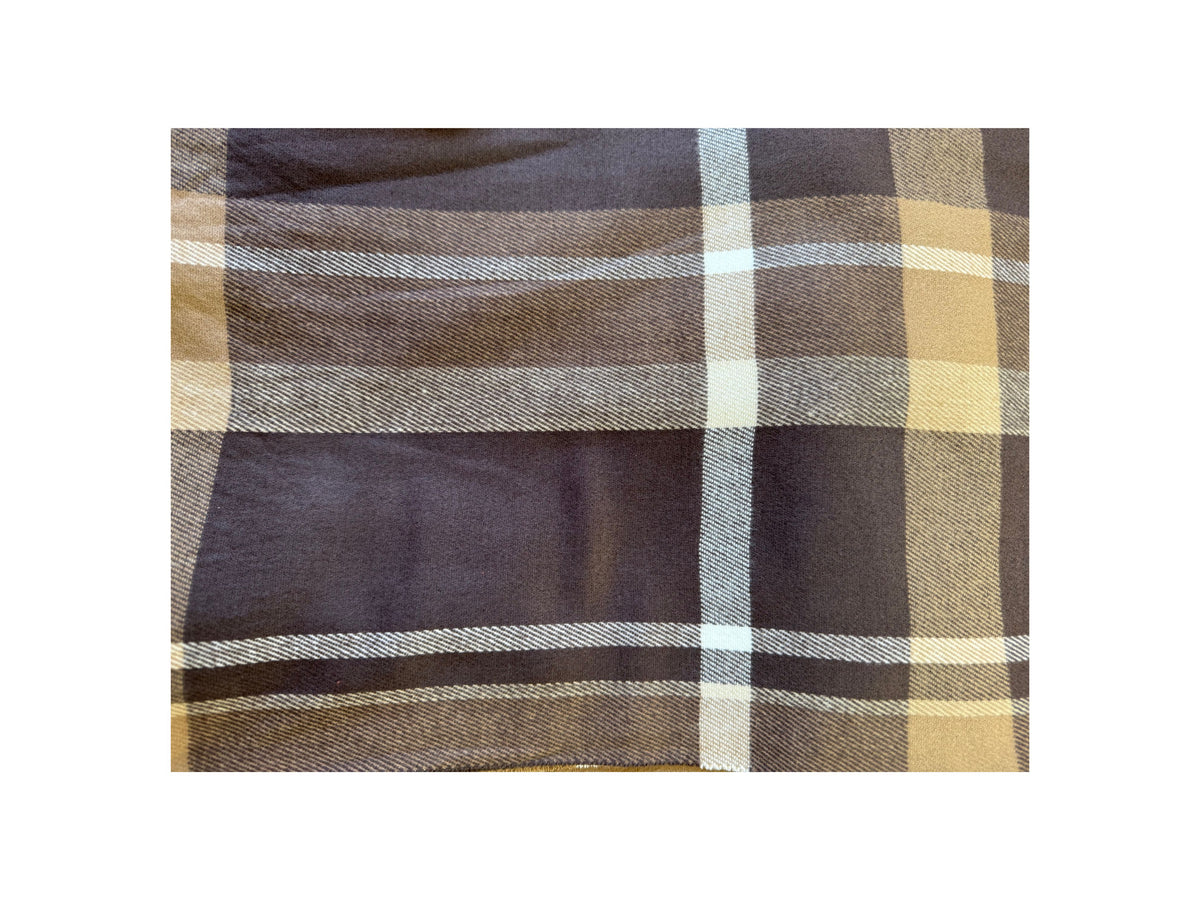 Close-up of a Scottish plaid cashmere scarf in brown, tan, and white checkered patterns.