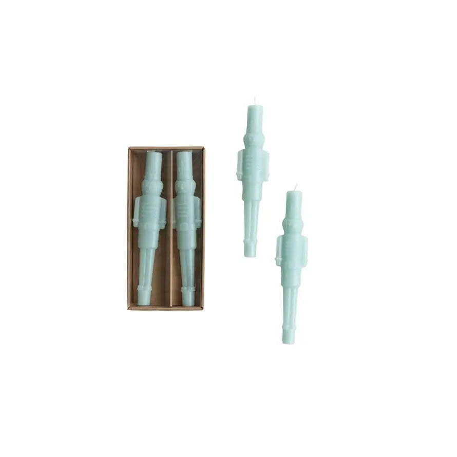 Unscented mint-colored taper candle shaped like a classic nutcracker standing upright.