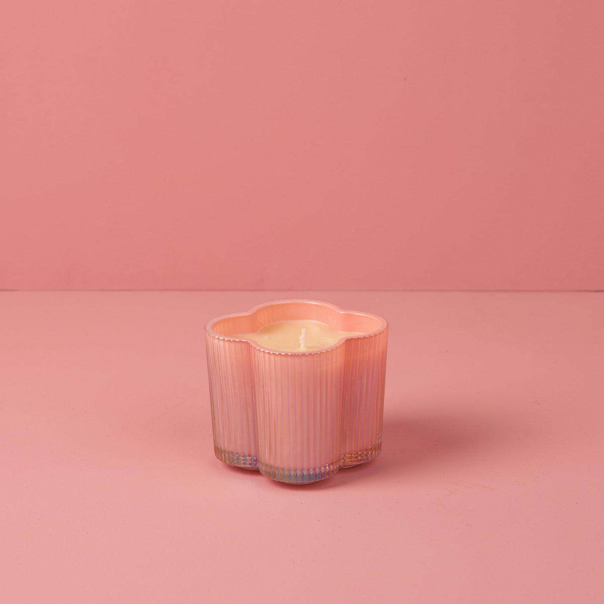 Sweet Grace Collection candle in a cylindrical glass jar with a white wax surface.