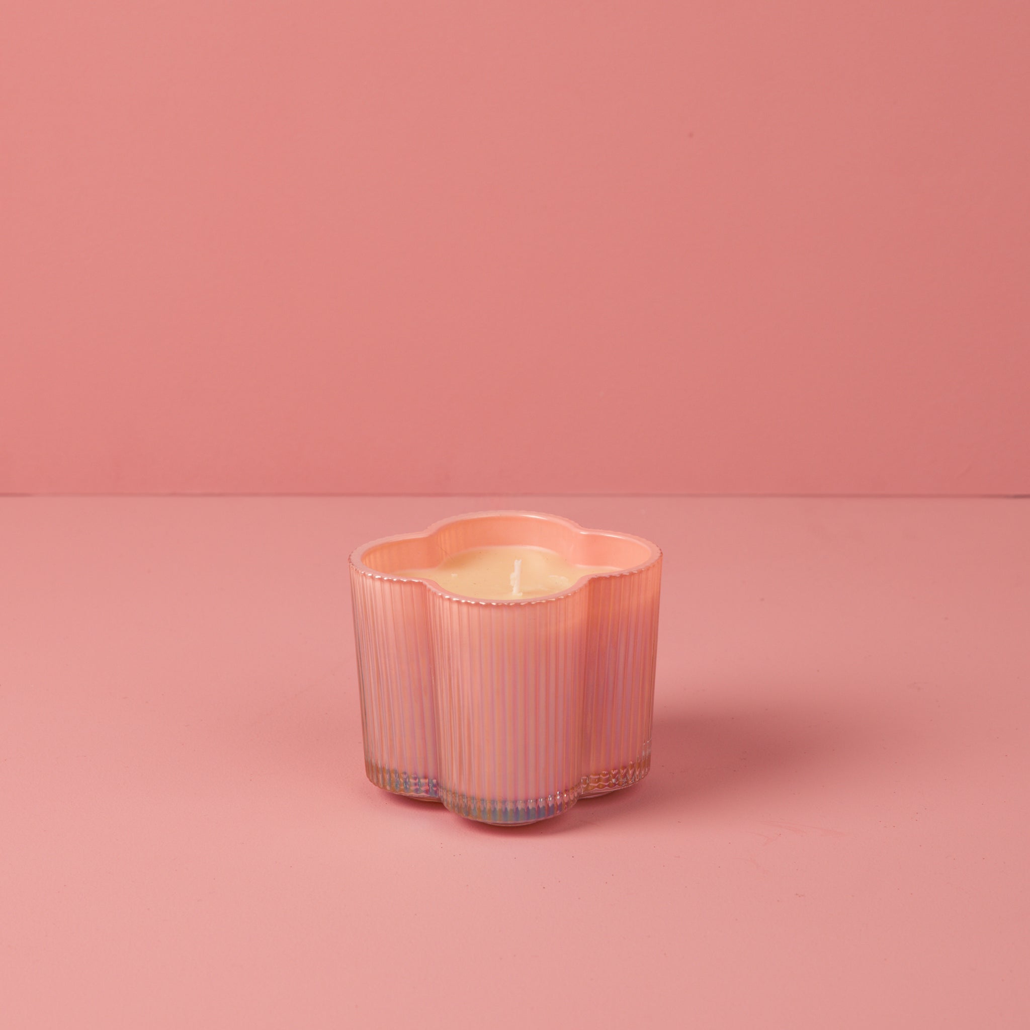 Sweet Grace Collection candle in a cylindrical glass jar with a white wax surface.