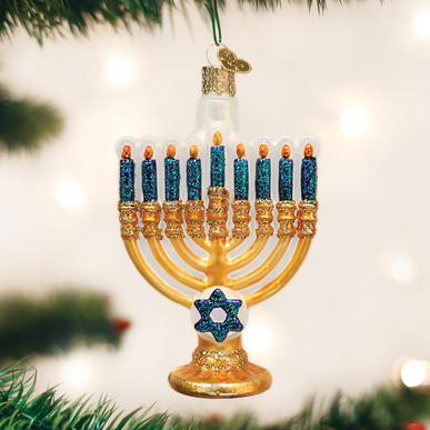 Glass menorah ornament with gold base, blue glitter candles, and a Star of David on a tree branch.