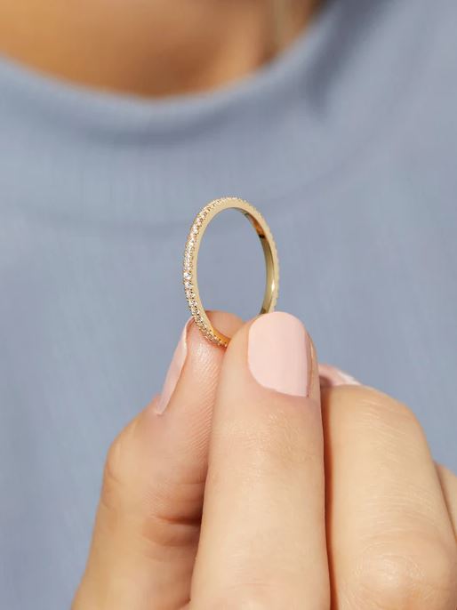 Celine Eternity ring in gold-toned metal with a band encrusted with cubic zirconia stones.