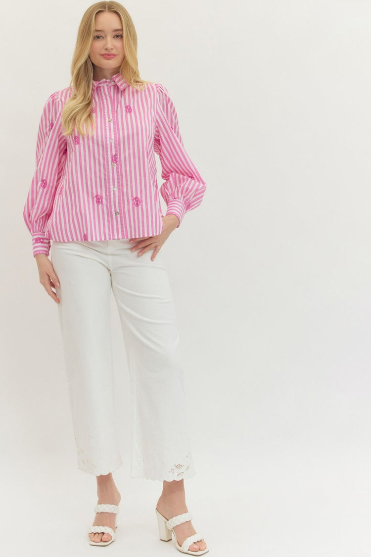 Woman wearing a pink and white striped Madeline long sleeve top with embroidered accents.