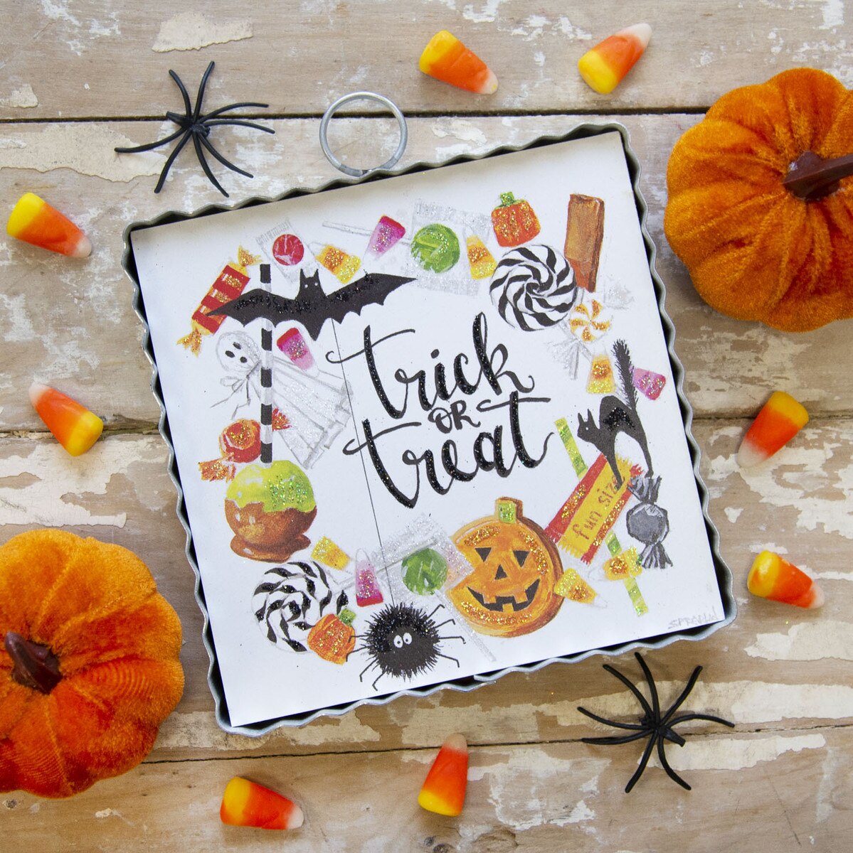 Mini Trick or Treat Wreath Print in a metal frame surrounded by candy corn and pumpkins.