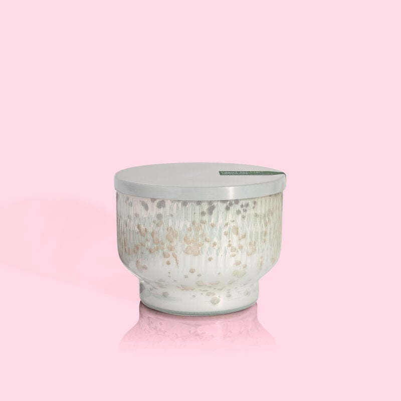 Crystal Pine Holiday Mercury Inverted Jar candle with a silver lid on a pink background.