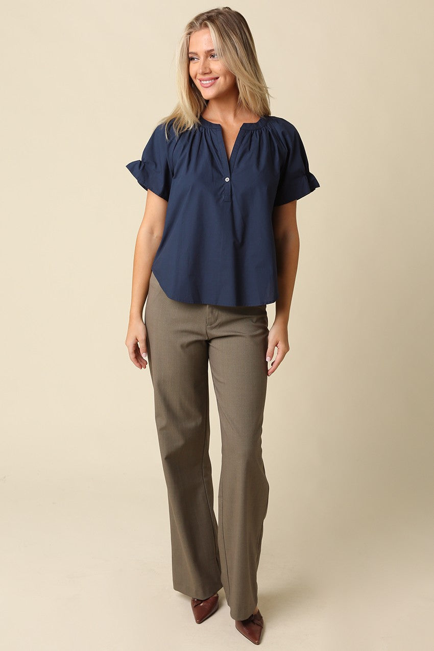 Woman wearing a navy blue Hylee Ruffle Sleeve Peasant Blouse with olive green trousers.