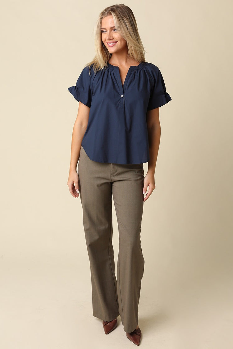 Woman wearing a navy blue Hylee Ruffle Sleeve Peasant Blouse with olive green trousers.