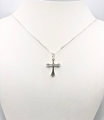 Silver cross necklace with five cubic zirconia stones on a white mannequin bust.