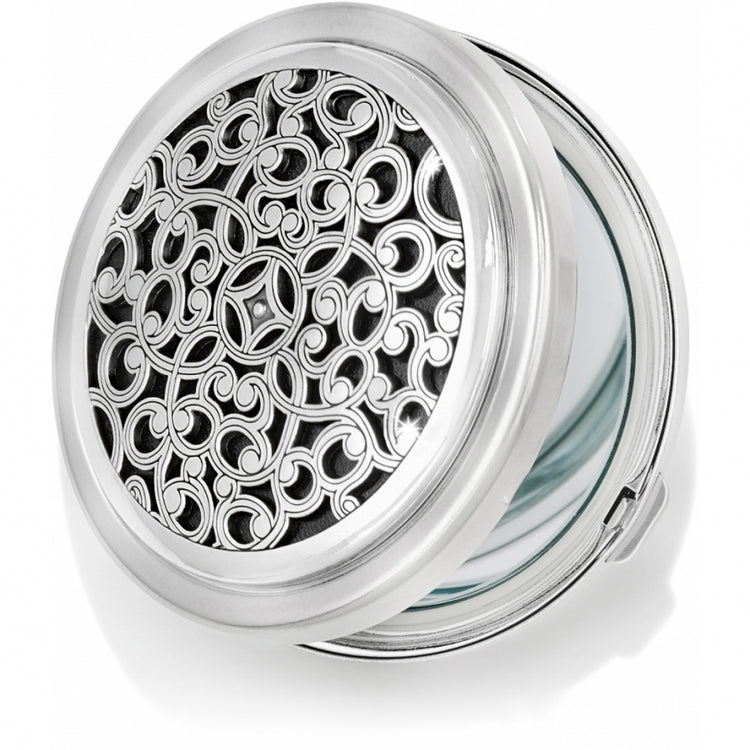 Silver-plated Serendipity Compact Mirror with an intricate sculpted scrollwork design on the lid.