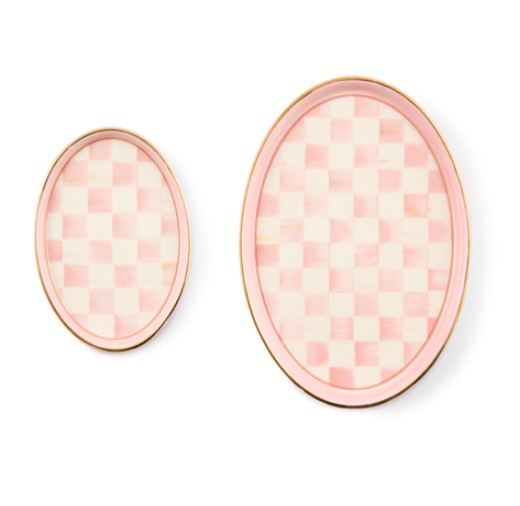 Set of two oval ceramic trinket trays with pink and white checkered pattern and gold rims.