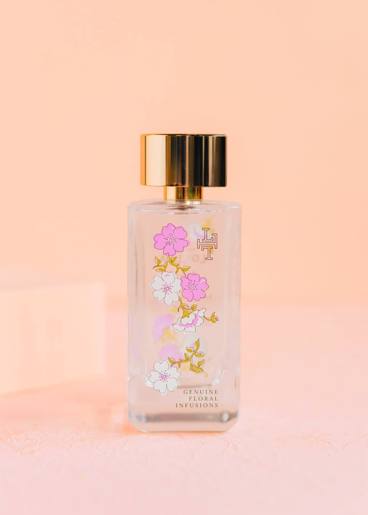 Relax Eau De Parfum bottle with delicate blossom field label on clear glass
