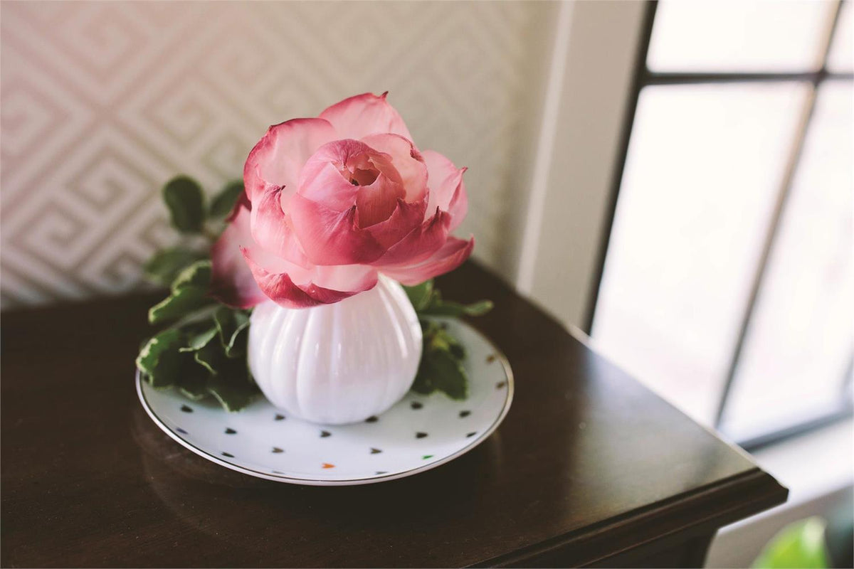 Sweet Grace flower diffuser bottle with a pink blooming silk flower stem emerging from the neck.