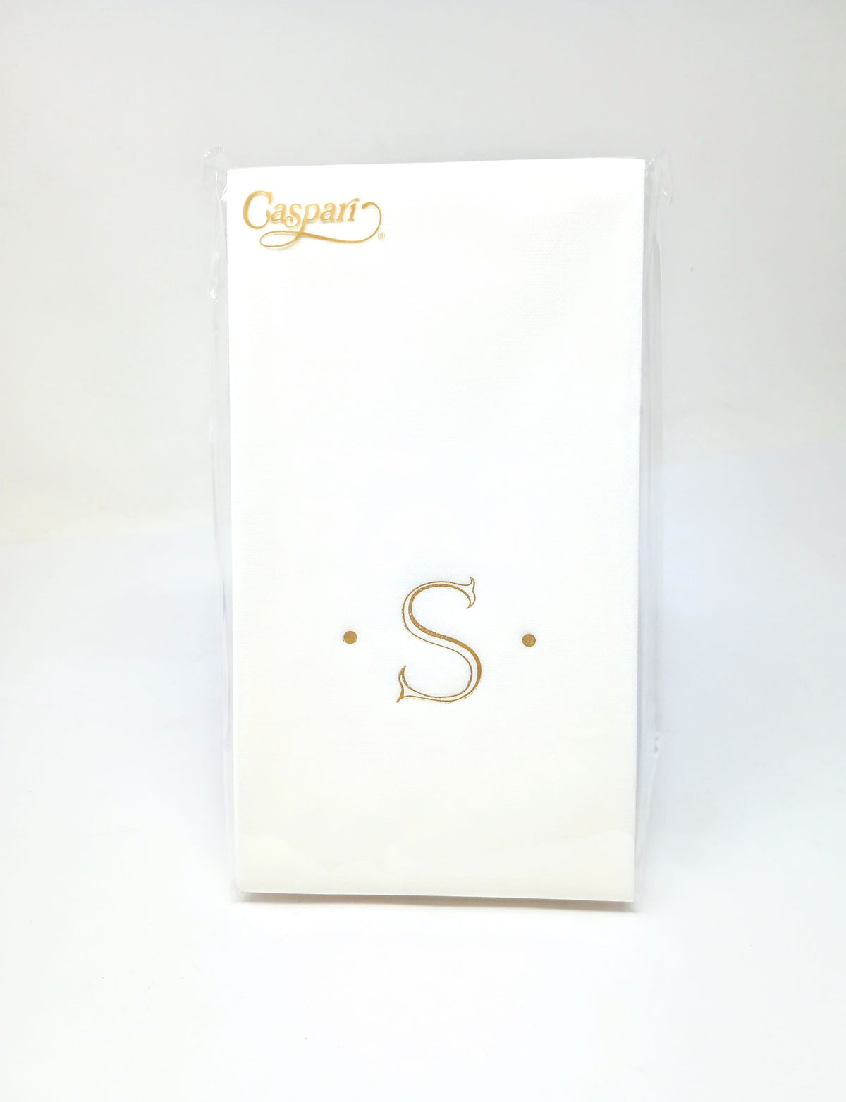 White paper linen guest napkin with a gold monogrammed letter S between two dots.