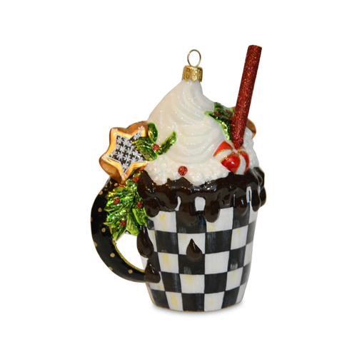Hot cocoa glass ornament featuring a checkered mug with whipped cream, chocolate drip, and a straw.