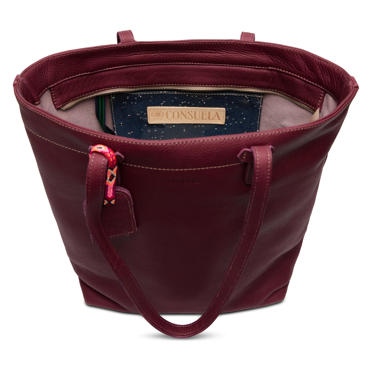 Plum Daily Tote in pebble leather with zipper closure, interior slide pocket, hook-clip lanyard, and attached bag tag.