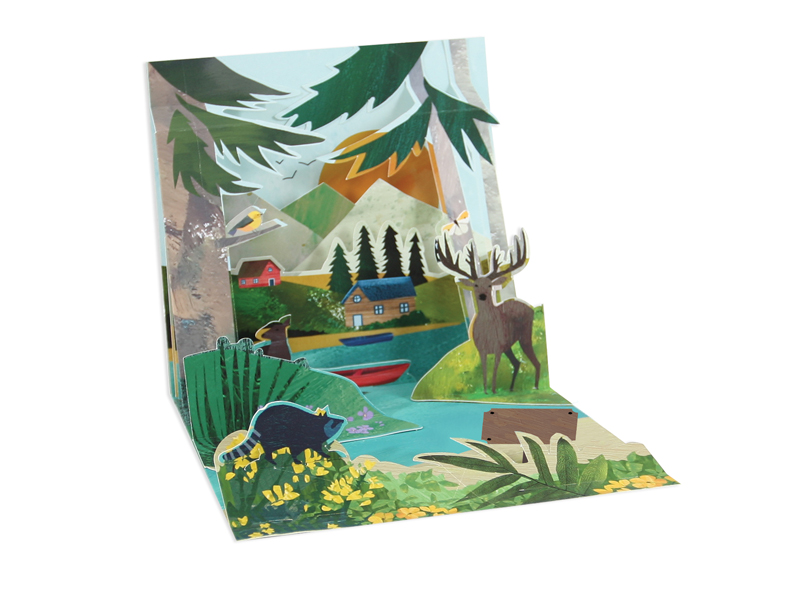 Square white card with gold foil text reading 'Adventure Awaits' inside a mountain lake silhouette.