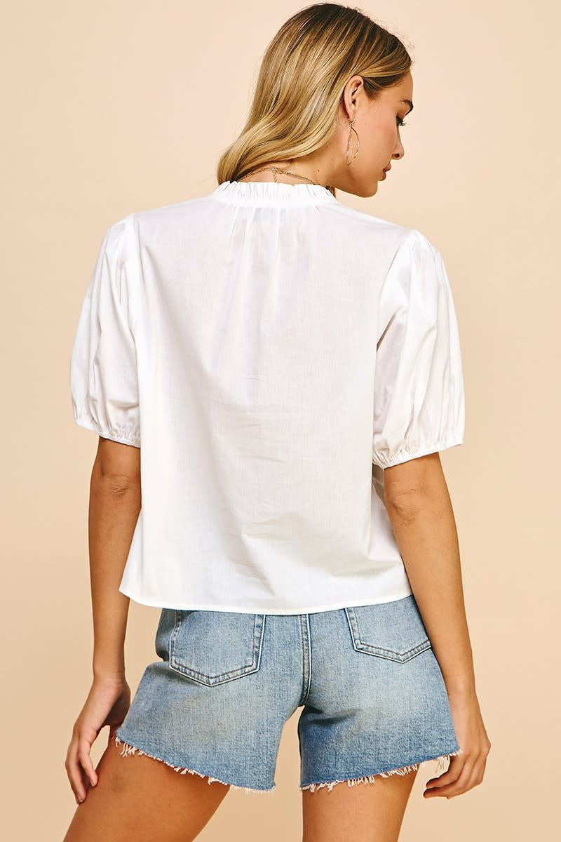 Back view of white Ivy short sleeve woven top with V-neck ruffle detail