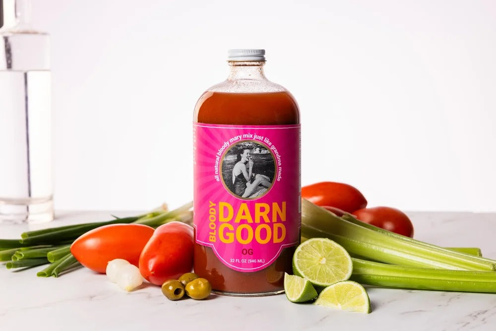 OG Bloody Mary Mix 32 oz bottle with fresh tomatoes, celery, limes, olives, and green onions.