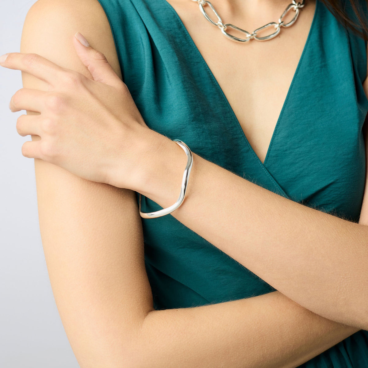 Silver plate wave bangle with Julie Vos hallmark on a neutral background.