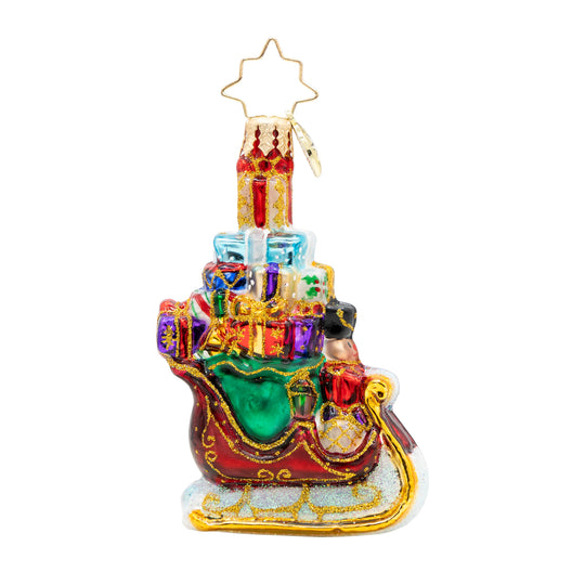 Glass Christmas ornament of a red sleigh filled with colorful gifts and a nutcracker figure.