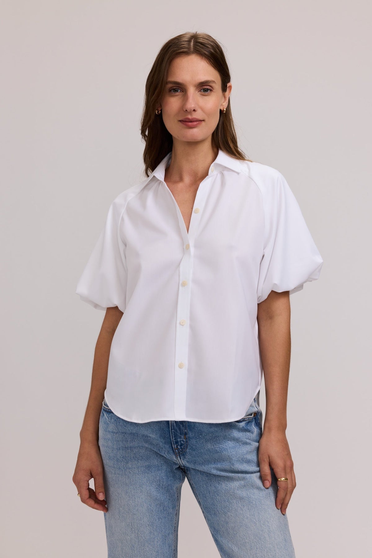 Woman wearing a white Paula Solid Puff Sleeve Shirt in cotton twill with blue jeans.