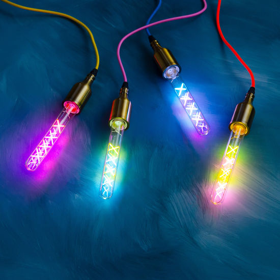 Four glass bulbs with 'X' patterns inside, lit with pink, yellow, blue, and red lights, connected by colorful wires.
