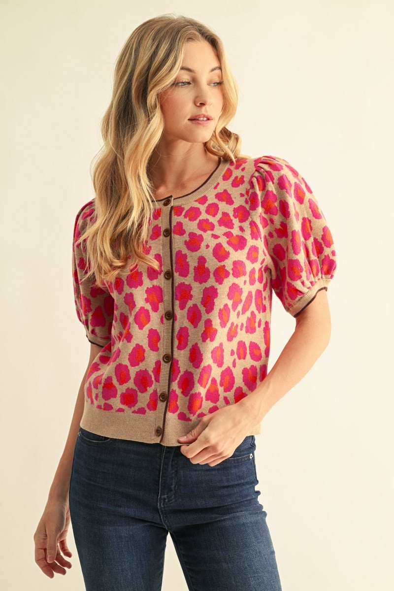 Woman wearing the Annie Leopard Sweater Cardigan in tan with pink and orange leopard print.