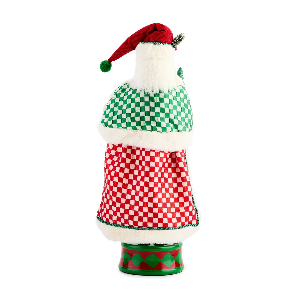 Back view of a tall nutcracker wearing a red hat and a green and red checkered coat with fur trim.