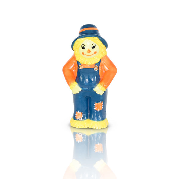 Ceramic scarecrow figurine wearing a blue hat, orange shirt, and blue overalls with patches.