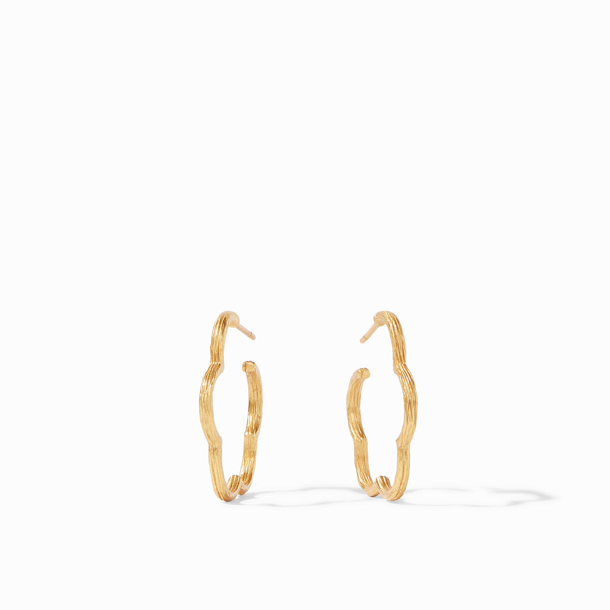 Slender gold hoop earring with a floral gardenia silhouette etched in textured detail.