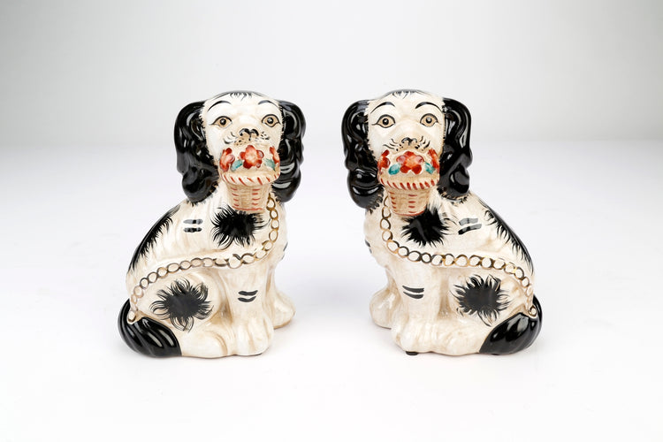Set of two Staffordshire dog figurines in black with white floral baskets