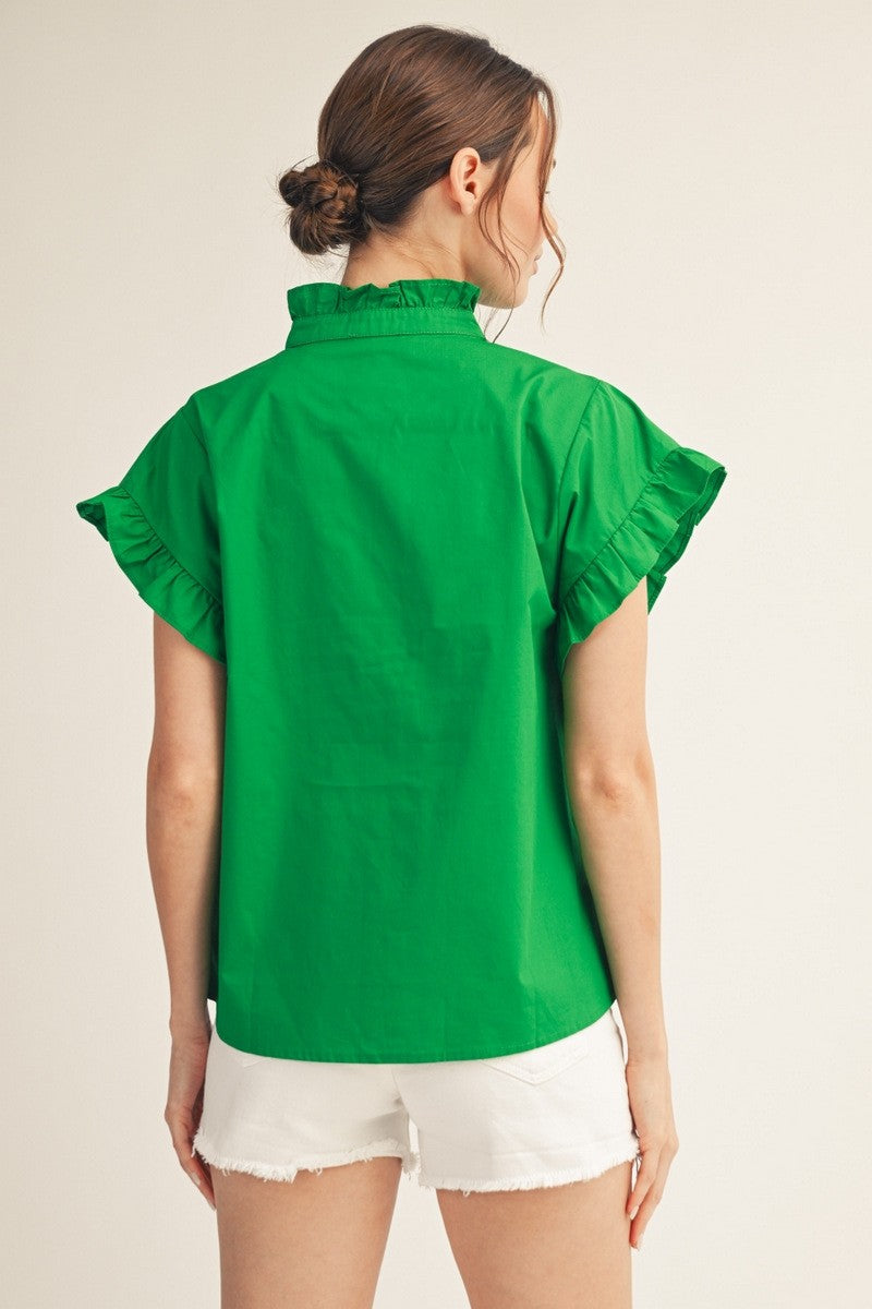 Back view of a woman wearing a green Elise Ruffled Detail Woven Top with white denim shorts.