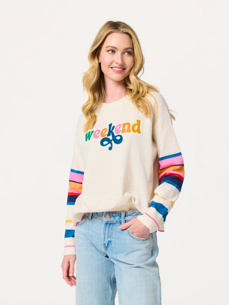 Woman wearing the Cassy Weekend lightweight boxy sweater with rainbow-striped sleeves.