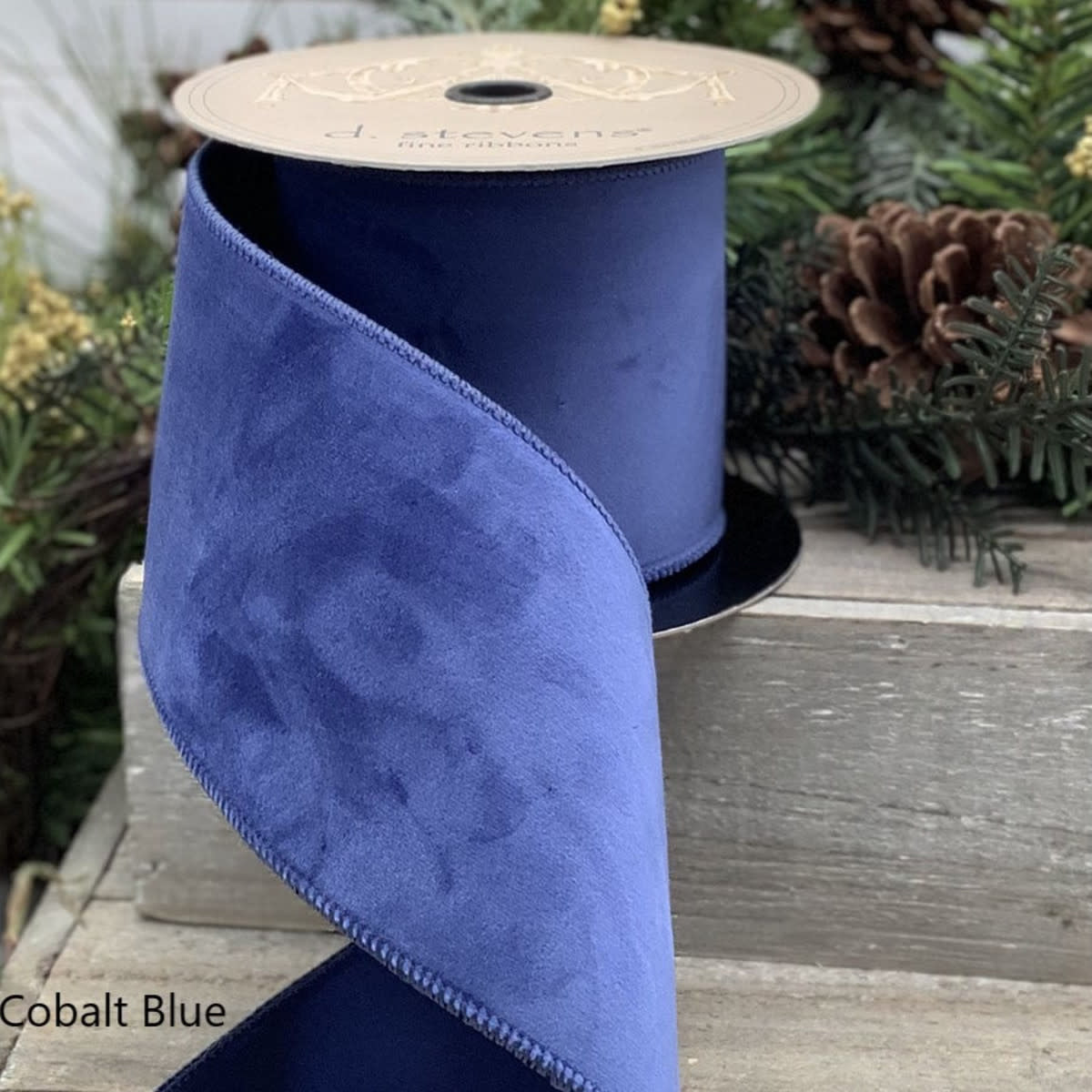Coil of cobalt blue velvet taffeta ribbon with a smooth sheen.