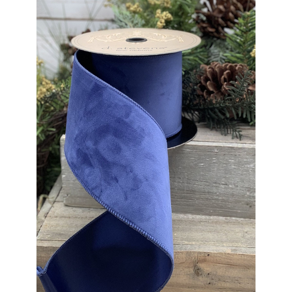 A roll of cobalt blue velvet ribbon measuring 2.5 inches wide by 10 yards long.