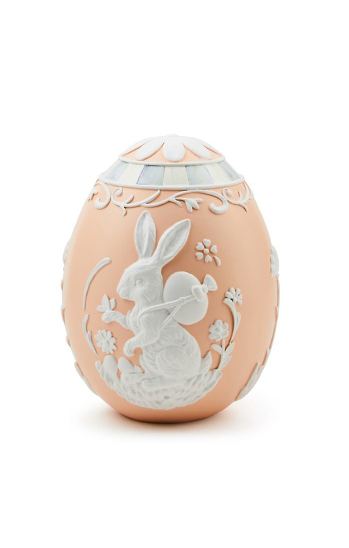 Small peach cameo egg featuring a white relief design of a bunny carrying an egg and floral accents.