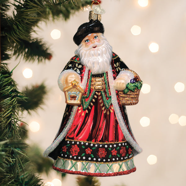 Slovak Father Christmas glass ornament with a black hat, red robe, lantern, and gift basket.