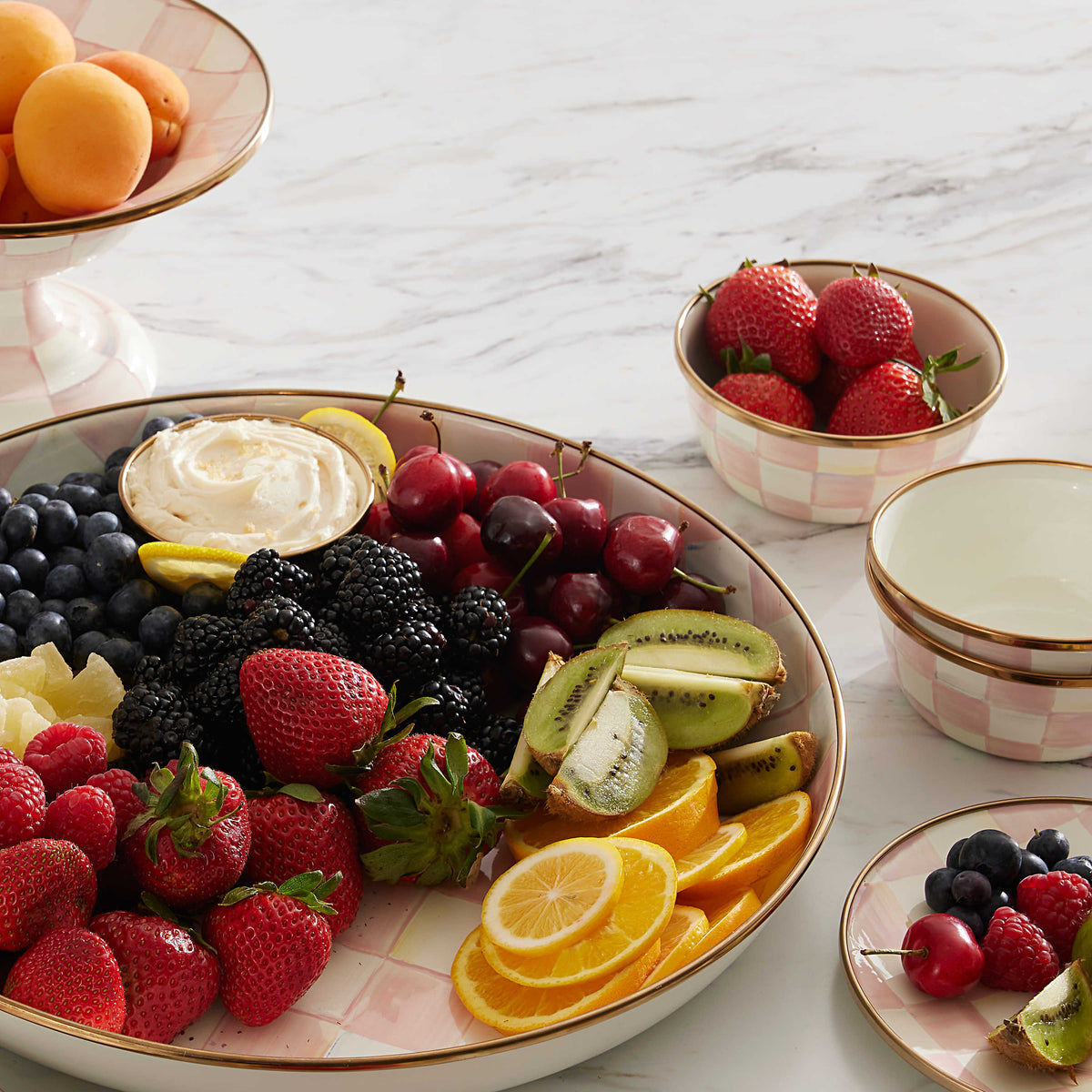 Hand-painted pink and white checkered enamel pinch bowl filled with fresh strawberries.