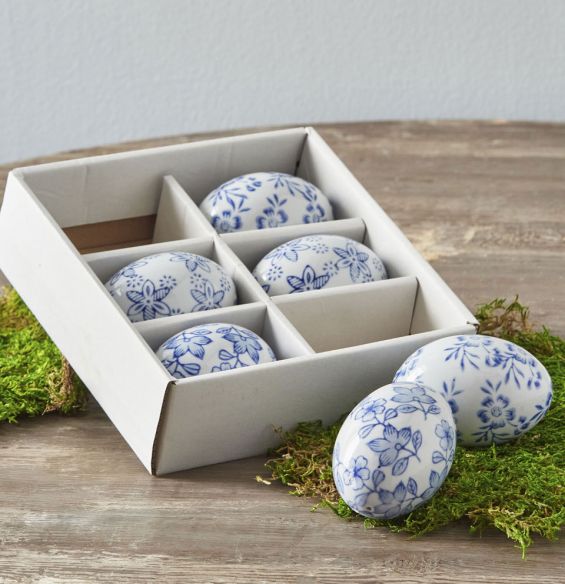 Porcelain egg with blue floral pattern on white background