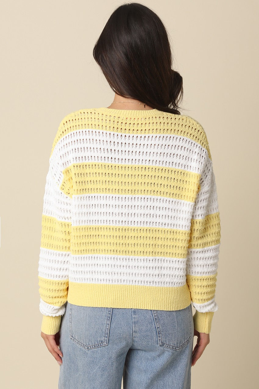 Back view of a woman wearing the Sadie Mesh Stripe Knit Sweater in yellow and white.