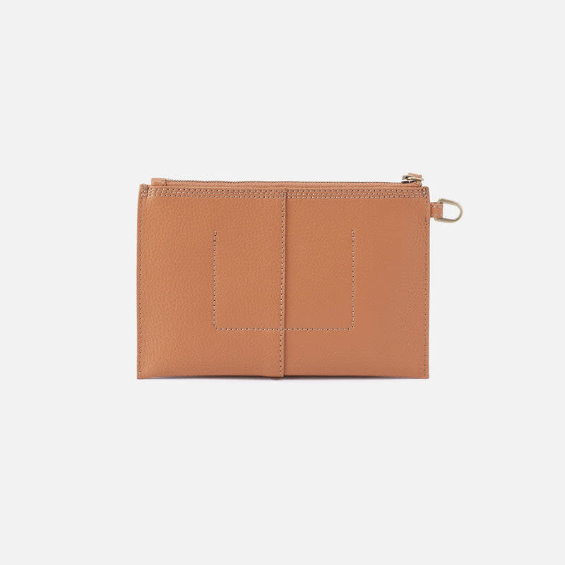 Biscuit-colored Vida small pouch with coconut shell interior, brass hardware, zip closure, and leather wristlet strap.